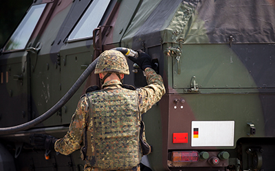 A soldier refuels his military vehicle on the way to a military chemical storage building.