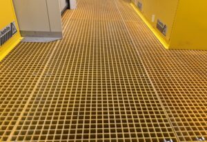 Yellow fiberglass grading over spill containment sump in building used for laboratory