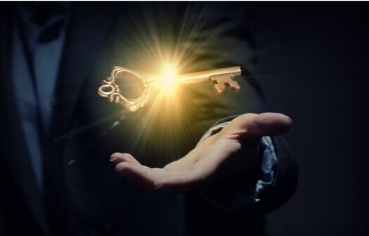 Man's Hand with a colden illuminated key floating above it