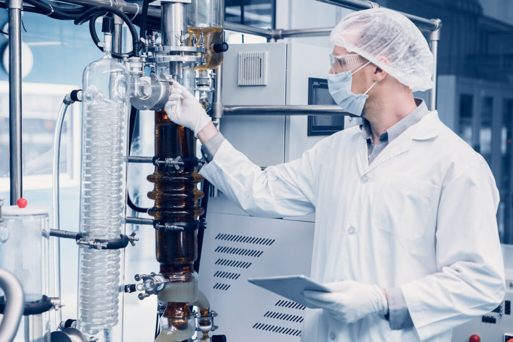 product factory scientist worker with oil extraction machine. Hemp oil extraction Thin Film Distillation Laboratory Plants Process.