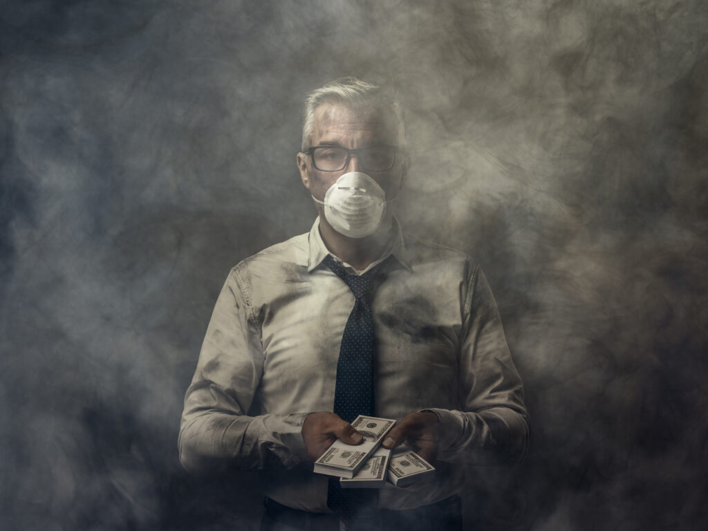 Business executive in smoky room wearing a mask and holding cash to pay fines