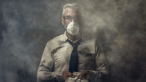Business executive in smoky room wearing a mask and holding cash to pay fines